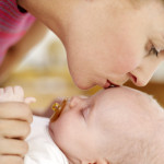 Woman Kissing the Top of a Baby's Head (3-6 Months)